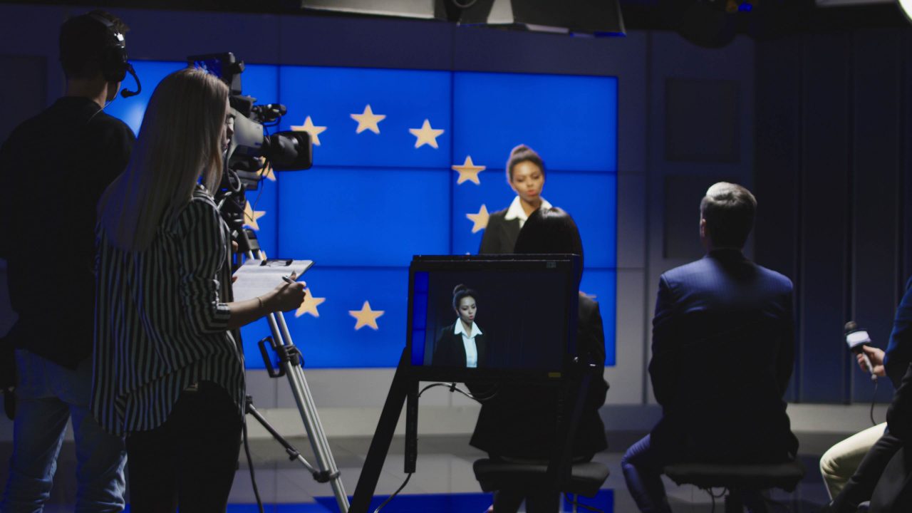 Moderatorin vor EU-Flagge