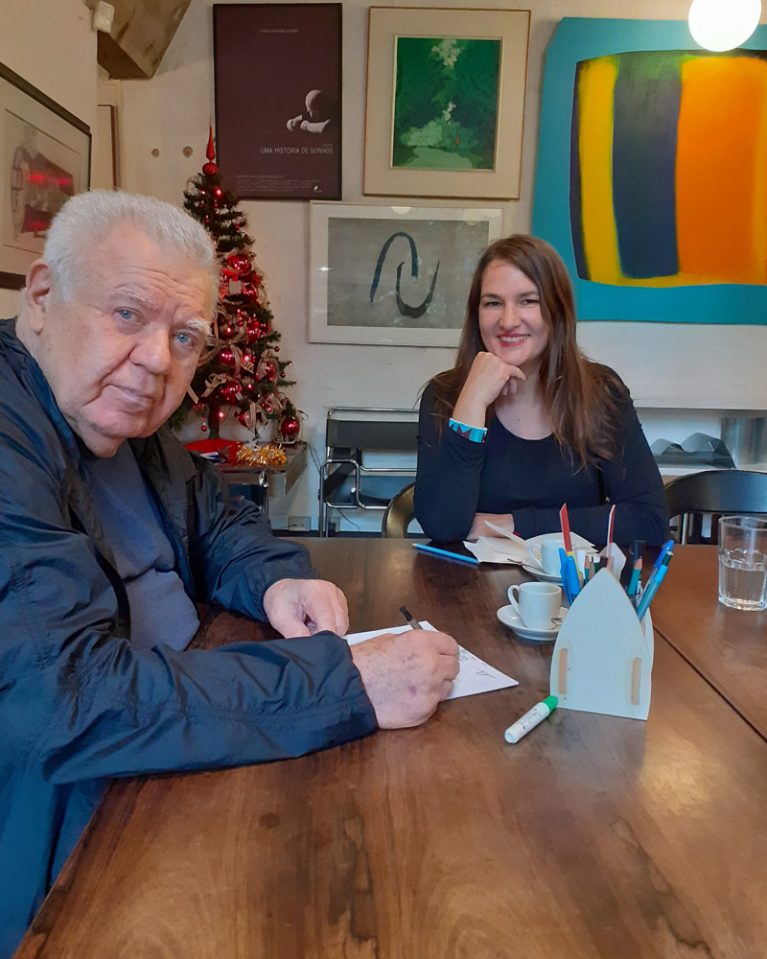 Der ehemalige Bürgermeister Jaime Lerner und Autorin Martina Farmbauer sitzen an einem Tisch.