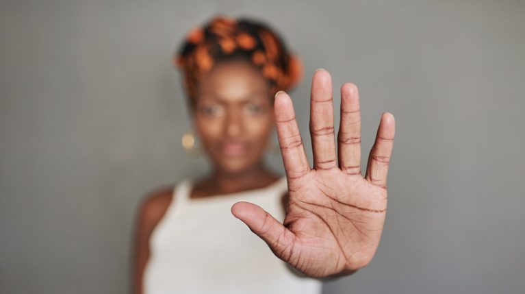 schwarze Frau hält Hand nach vorn als Stopp-Symbol