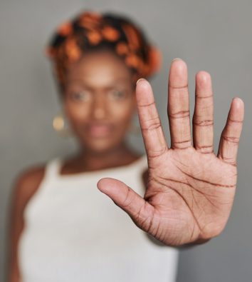schwarze Frau hält Hand nach vorn als Stopp-Symbol