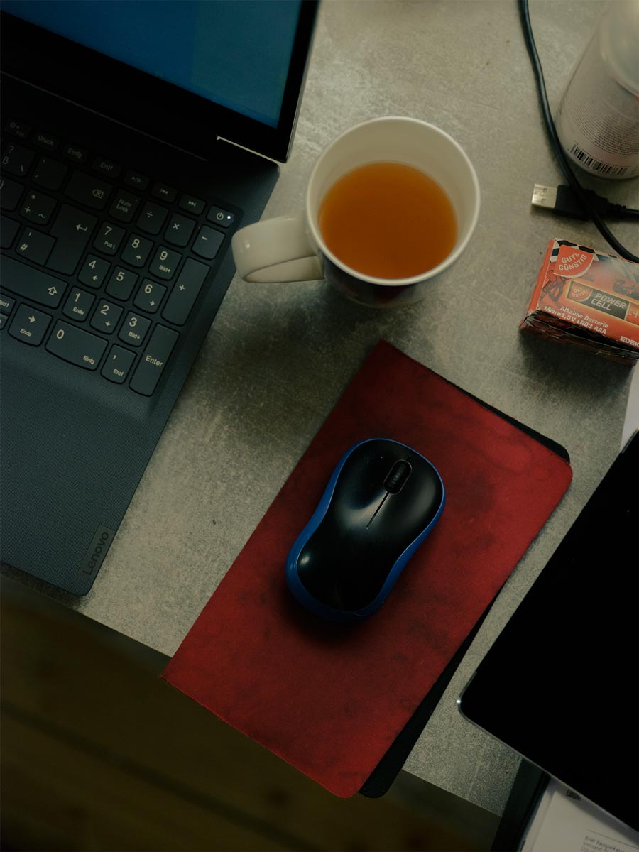 Eine Maus und ein Tee am Computer-Arbeitsplatz